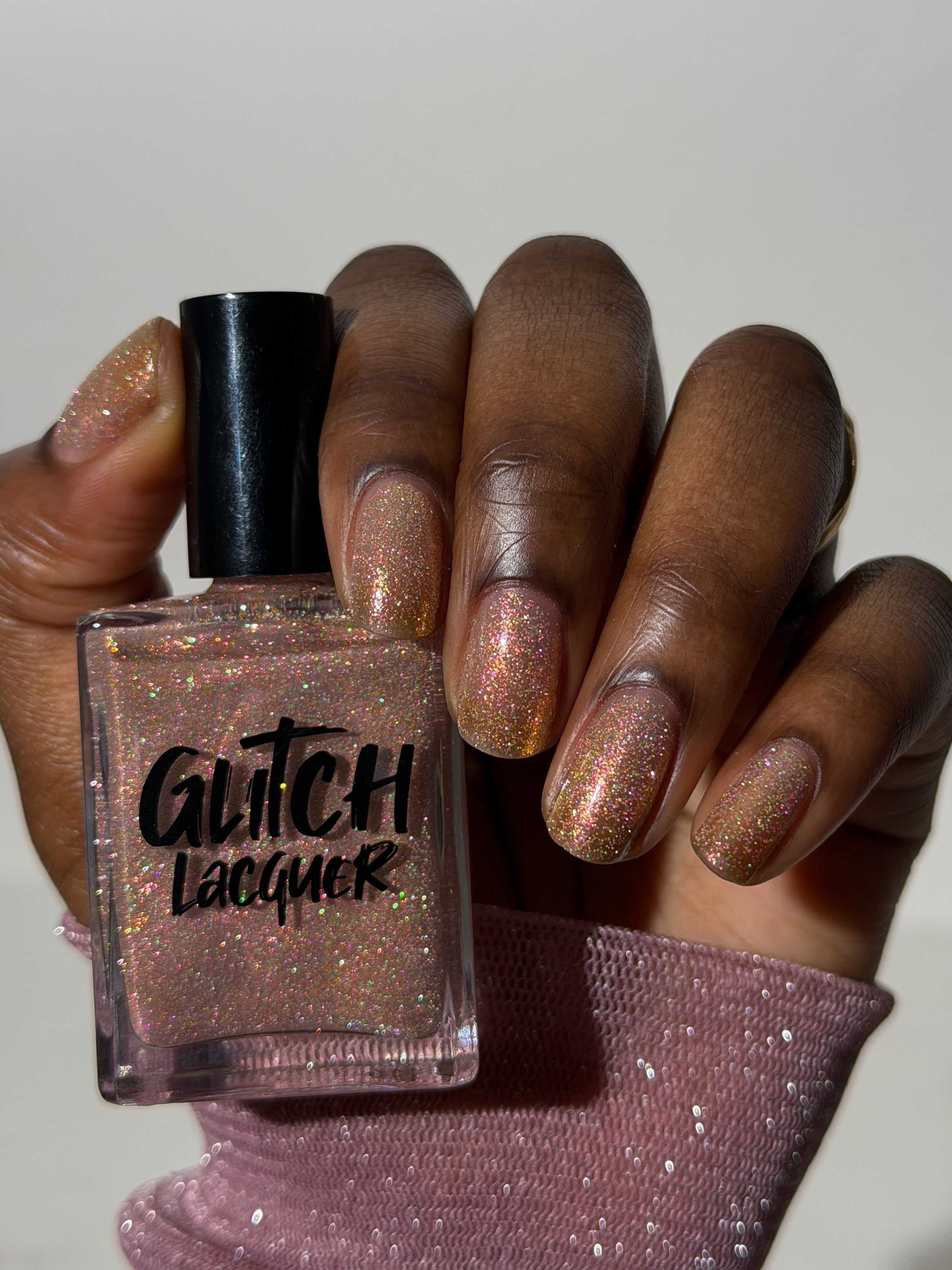 Resistance by Glitch Lacquer, sheer white with reflective glitter on a deep skin tone hand