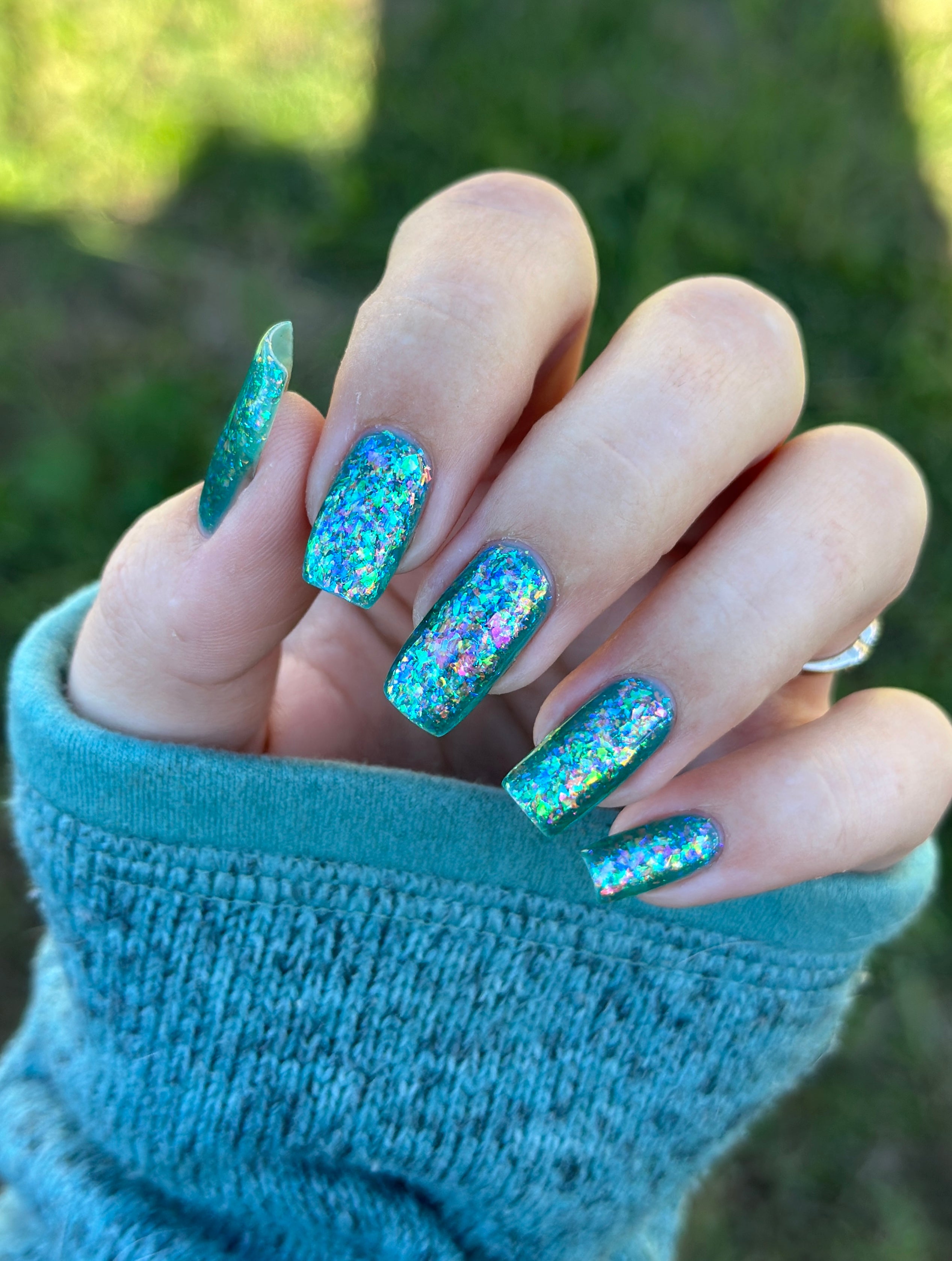 Medo by Glitch Lacquer, teal jelly with iridescent flakies on light-medium skin, long squoval nails