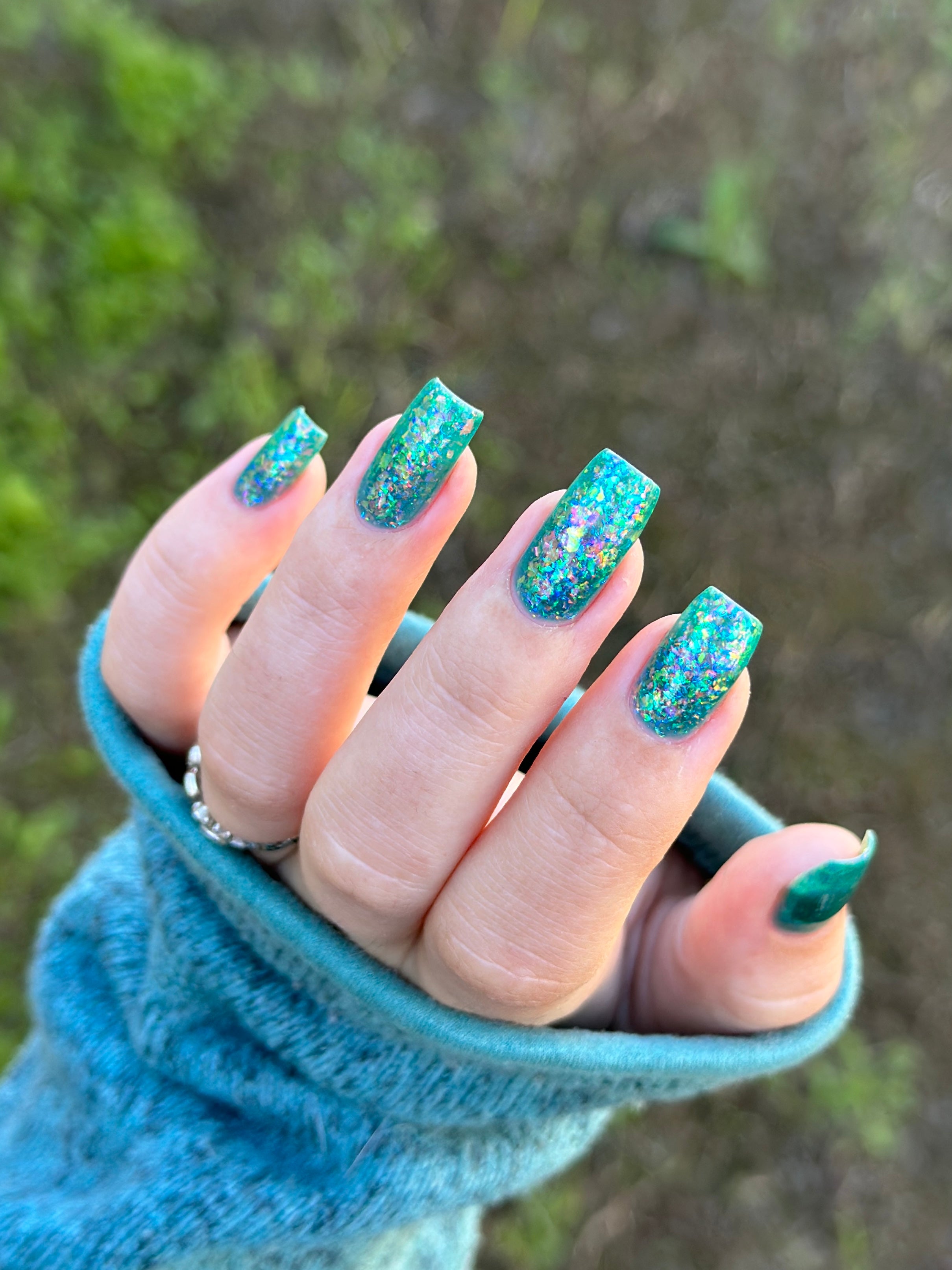 Medo by Glitch Lacquer, teal jelly with iridescent flakies on light-medium skin, square nails