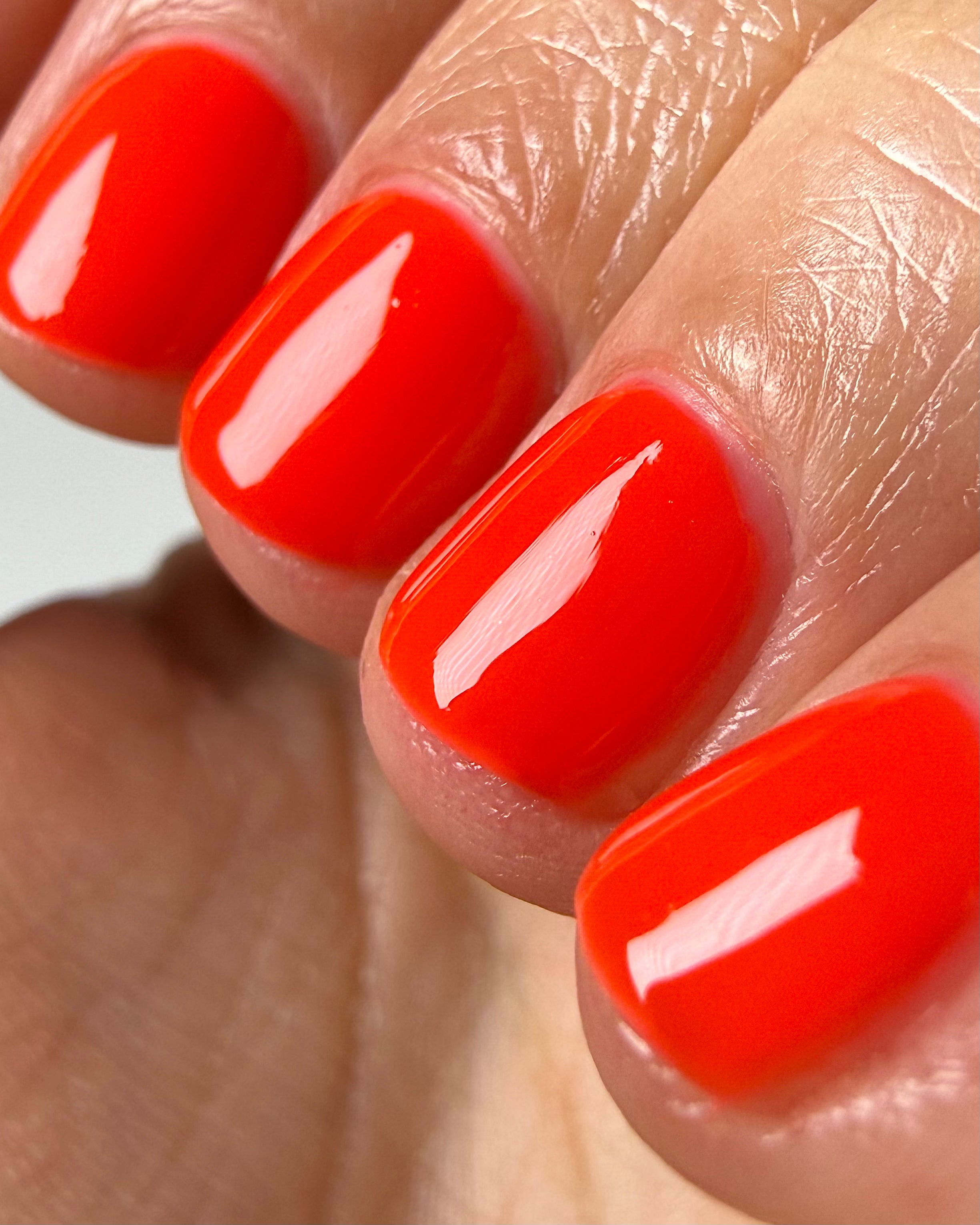 Palestinian Poppy by Glitch Lacquer, warm red crelly swatch on light-medium skin tone, round nails