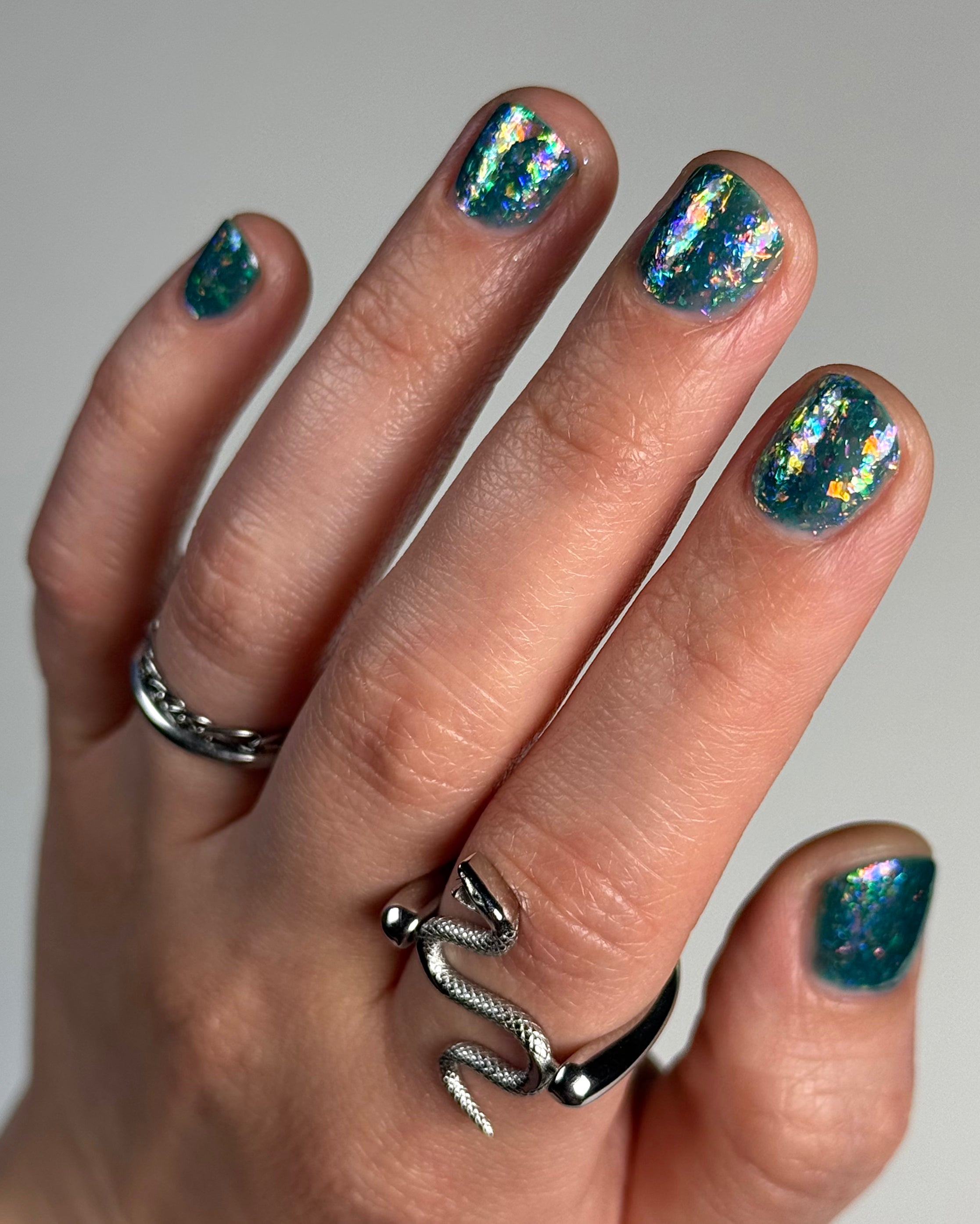 Medo by Glitch Lacquer, teal jelly with iridescent flakies on light-medium skin, short nails