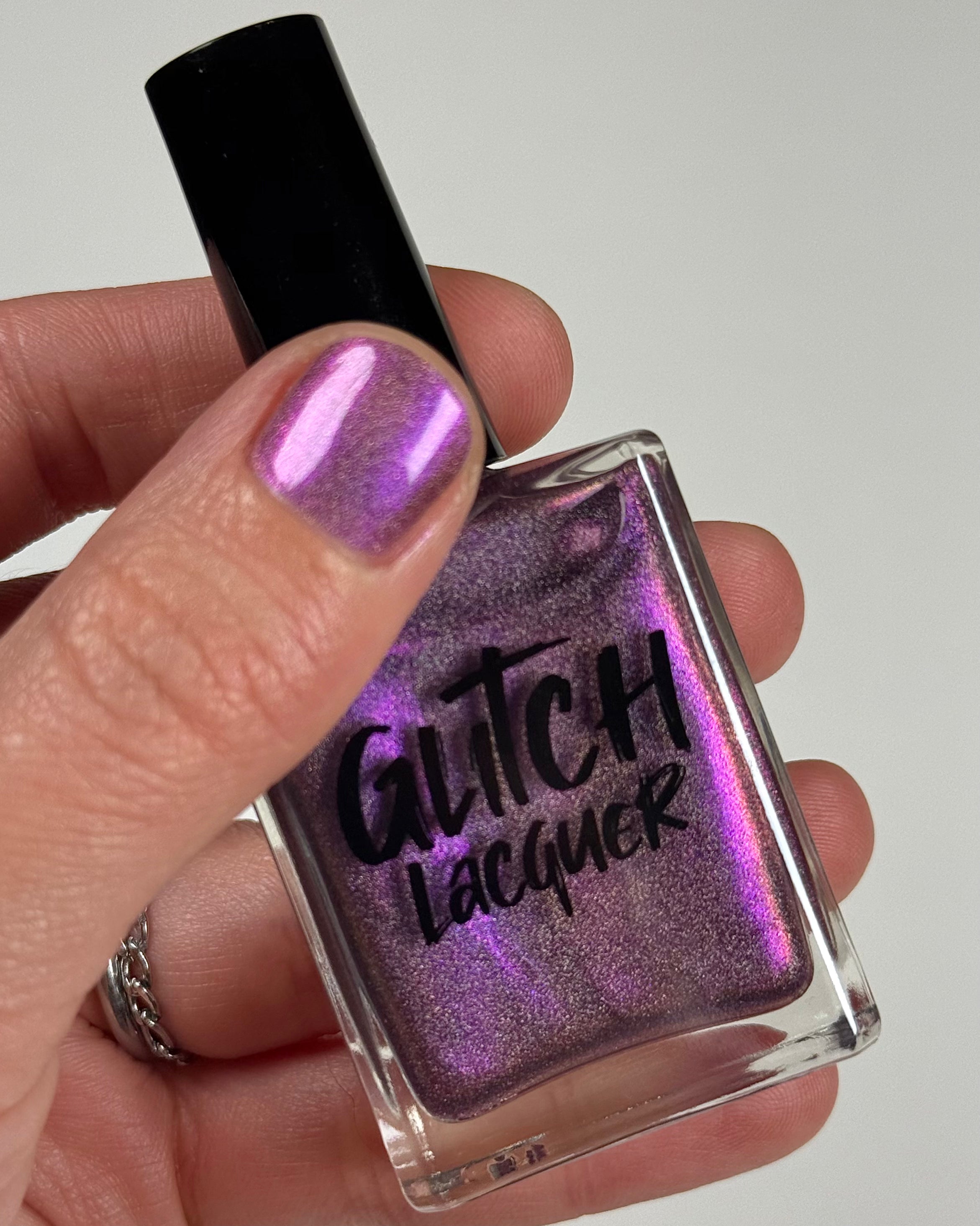 Keys to the Kingdom by Glitch Lacquer, berry multichrome holo bottle in hand, light-medium skin