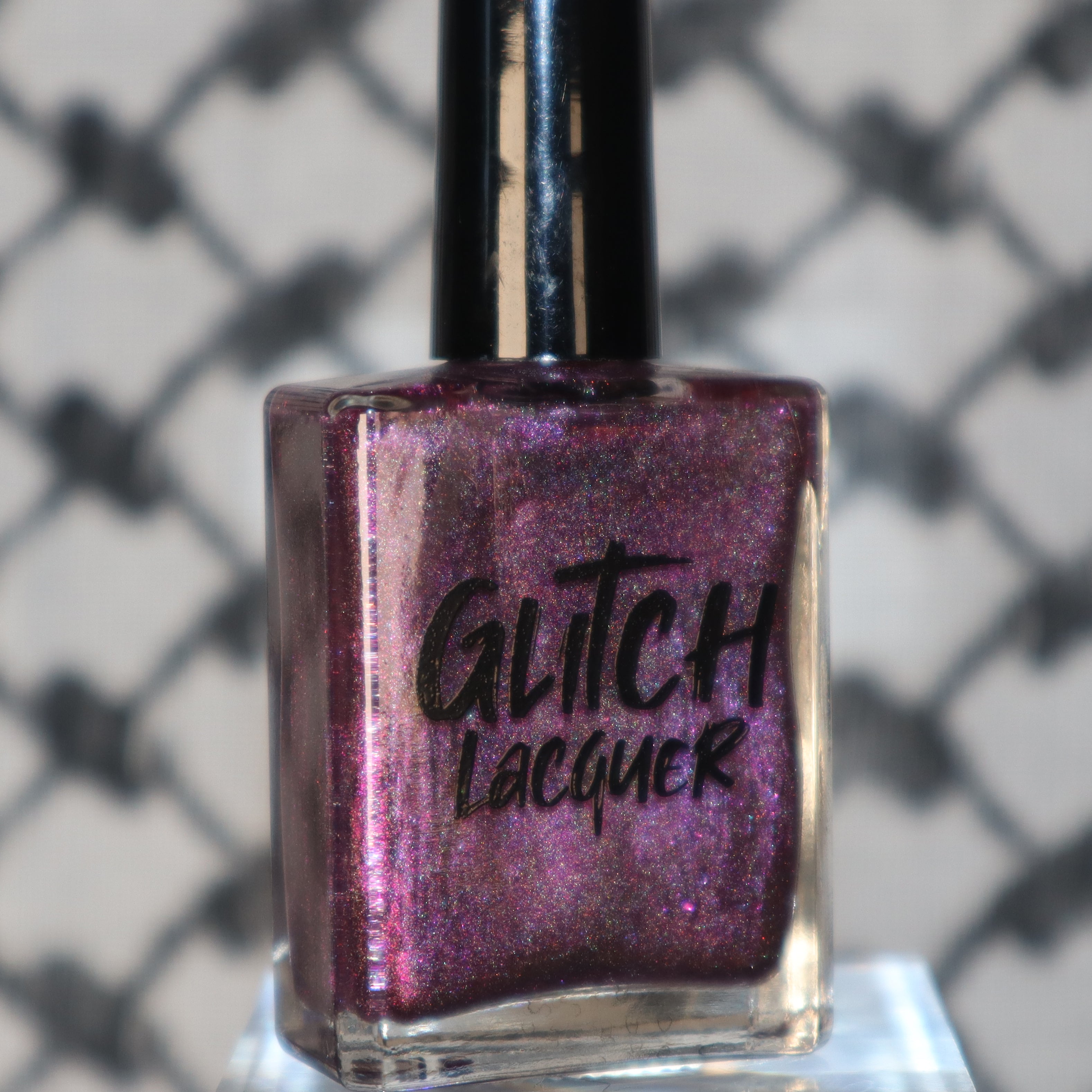 Keys to the Kingdom by Glitch Lacquer, berry multichrome holo bottle on patterned background