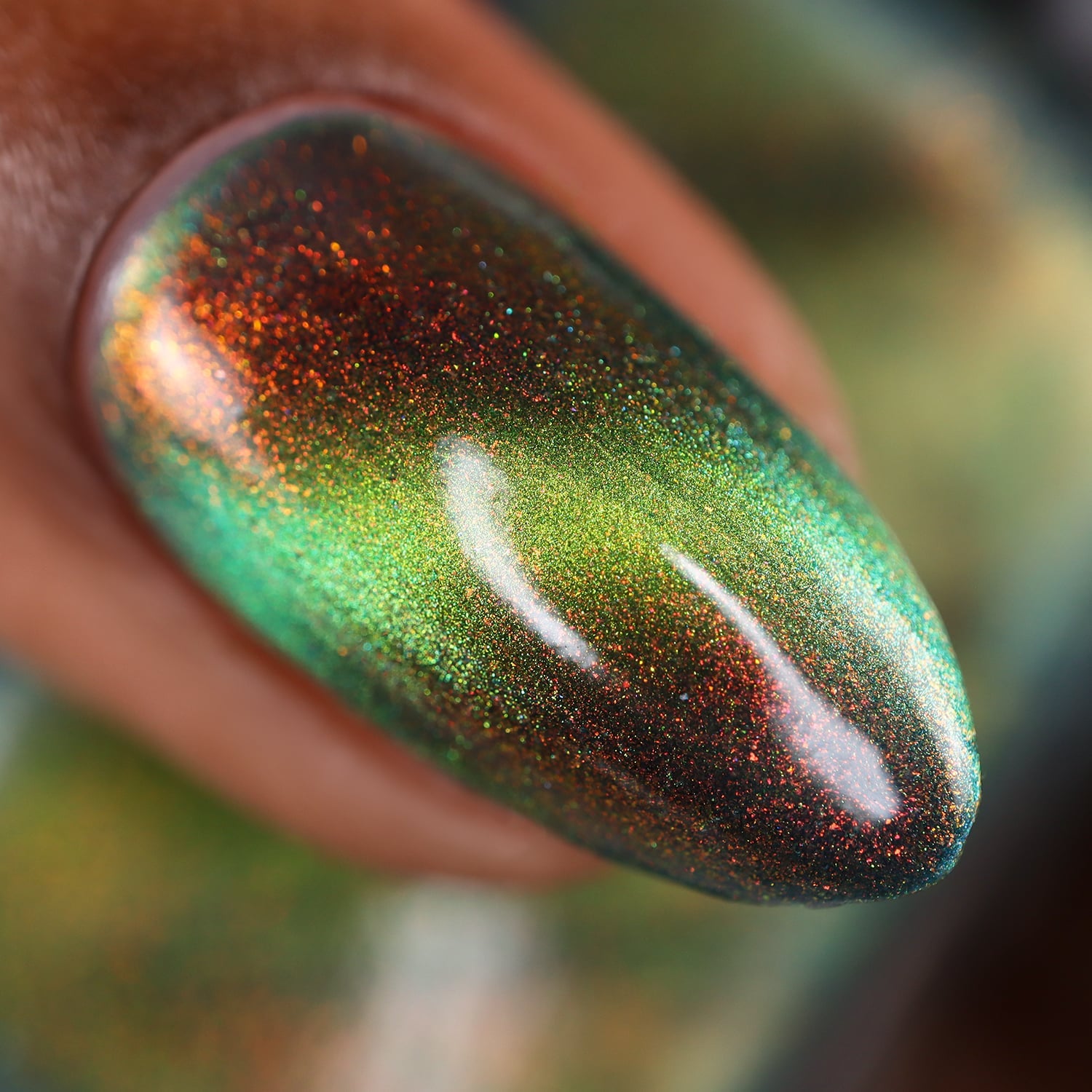 Magnetic multichrome shimmer Cadillacquer nail polish in I Found A Place, extreme macro swatch on a single almond-shaped nail showing a lime-green magnetic band across a deep forest-green field with vivid red-to-orange aurora shimmer particles, on medium skin tone, under studio lighting, swatched by @doseoflolade