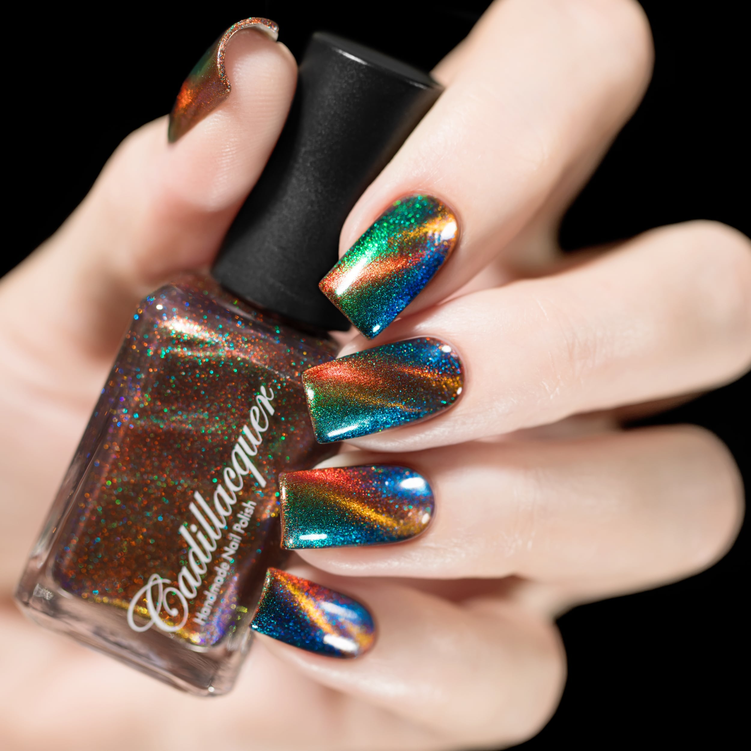 Holographic magnetic multichrome Cadillacquer nail polish in Once You See It, showing a square bottle with a sheer brick-red base packed with fine holographic particles held in hand against a black background, with four almond-shaped nails displaying a vivid copper-orange diagonal magnetic band over a deep teal-blue field with sweeping green and blue aurora shimmer shifts, light skin tone, studio lighting, swatched by @rafinails