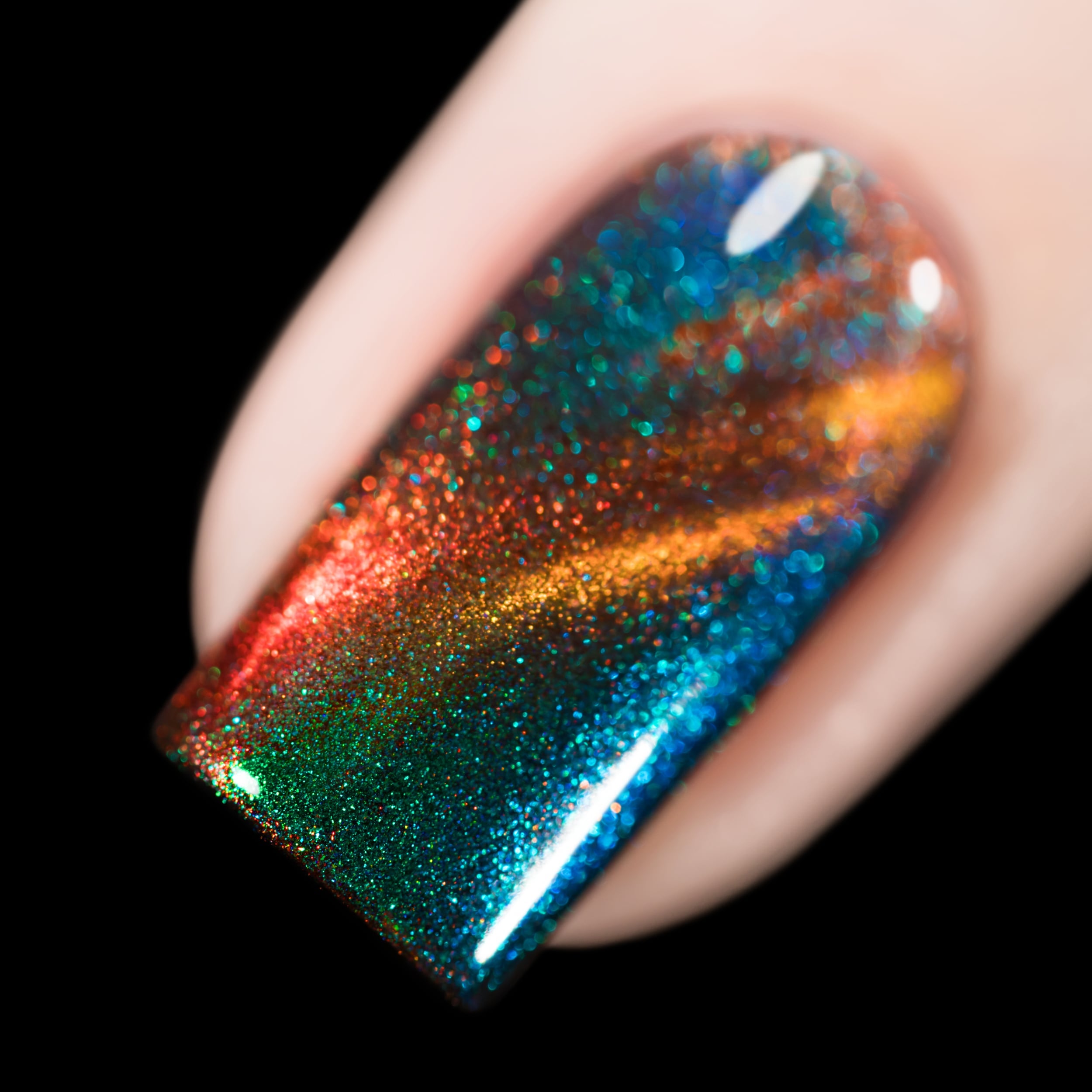 Magnetic holographic multichrome Cadillacquer nail polish in Once You See It, swatched on one square nail showing a diagonal amber-gold magnetic band sweeping across a deep green field, with vivid aurora shimmer flashing teal, cobalt blue, and orange-red across the surface, packed with fine holographic particles, light skin tone, direct flash lighting against black background, swatched by @rafinails