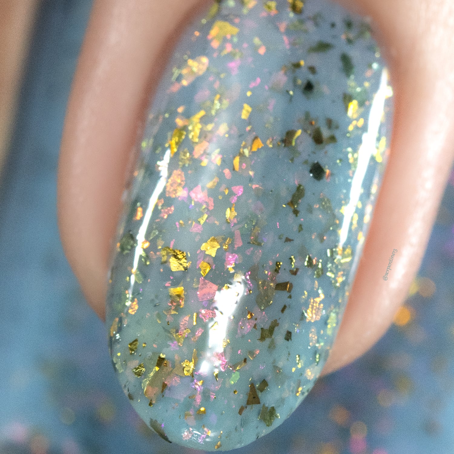 Cadillacquer Slow Mornings light blue gold chameleon iridescent crelly nail polish, macro single-nail swatch, light skin, studio lighting