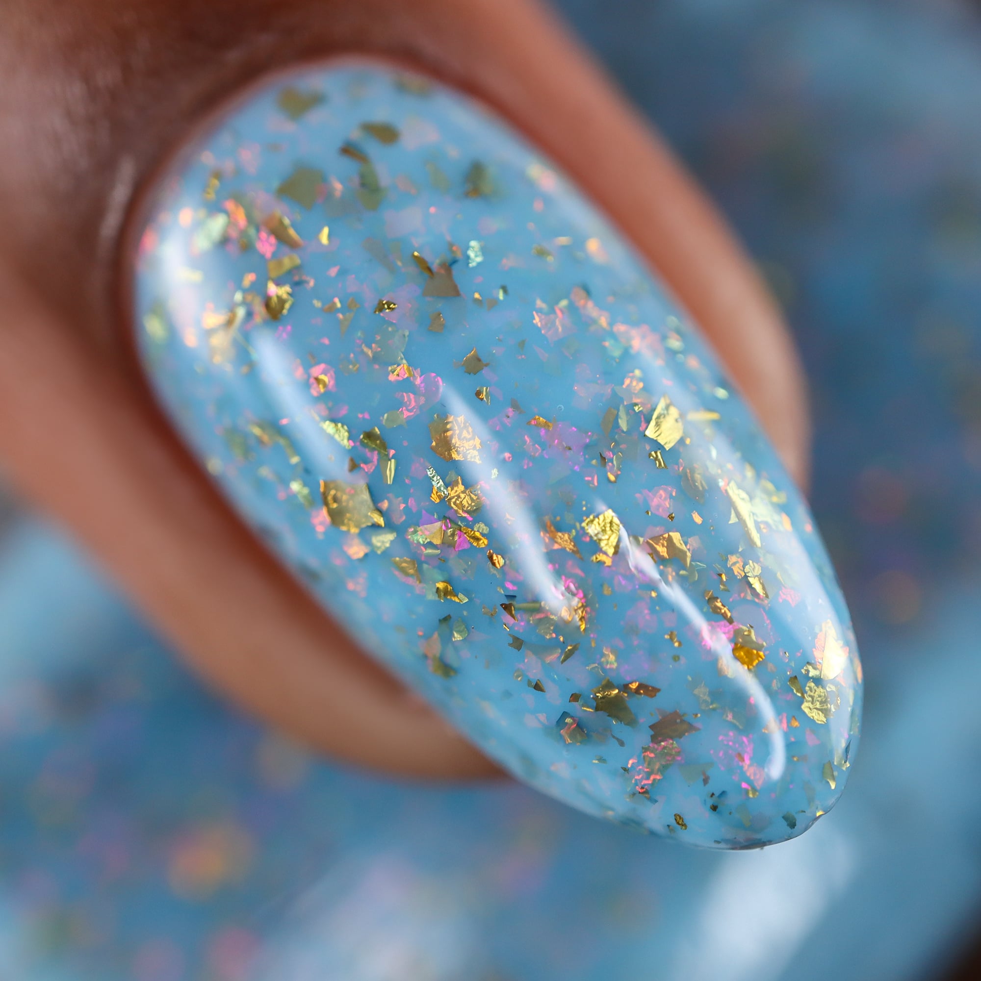 Cadillacquer Slow Mornings light blue gold chameleon iridescent crelly nail polish, macro single-nail swatch, light-medium skin, bright daylight lighting