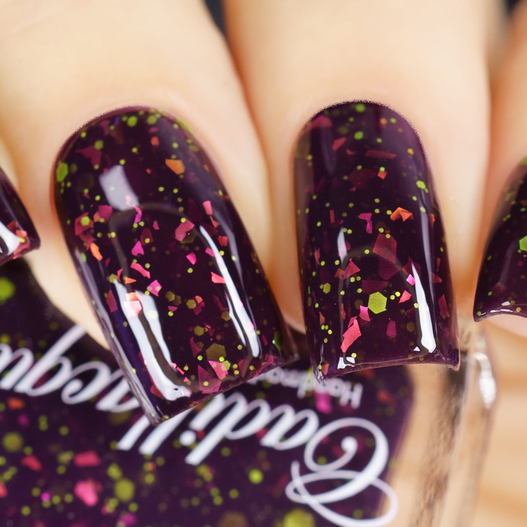 Thermal glitter-and-flake Cadillacquer nail polish in Strange Happenings, shown in cold state on four oval nails, displaying a near-black blackened eggplant base packed with large magenta-pink and burnt orange iridescent flakes alongside matte neon yellow-green glitter in mixed sizes, light skin tone, studio lighting, swatched by @yyulia_m