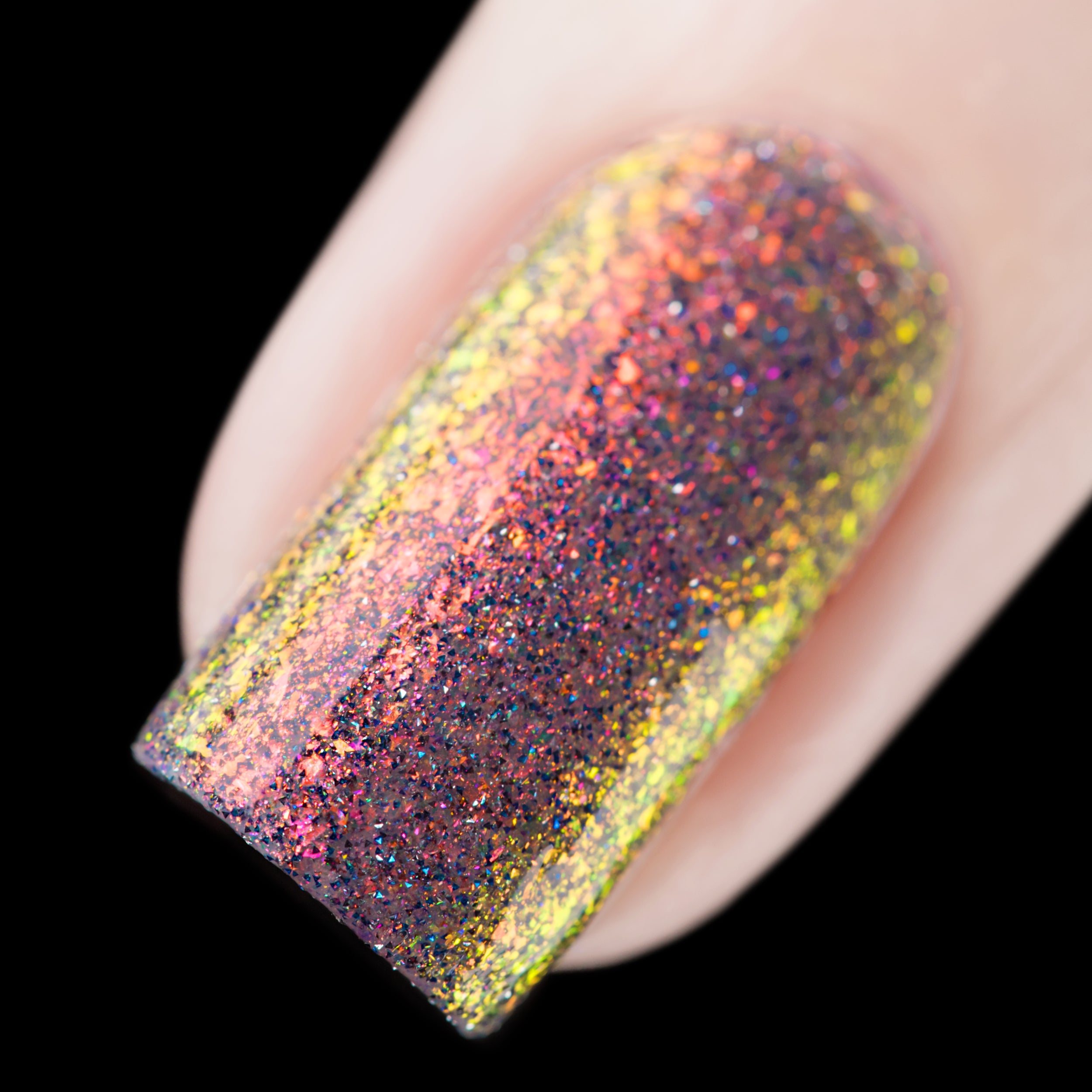 Multichrome flaky glitter Cadillacquer nail polish in You Wished For This, extreme macro swatch on a single square nail showing dense iridescent micro flakes shifting from orange-red through golden yellow to hot pink-magenta, scattered with teal-blue and charcoal holographic glitter sparks over a near-black sheer base, light skin tone, studio lighting with directional highlight revealing the full colour spectrum across the nail surface, swatched by @rafinails
