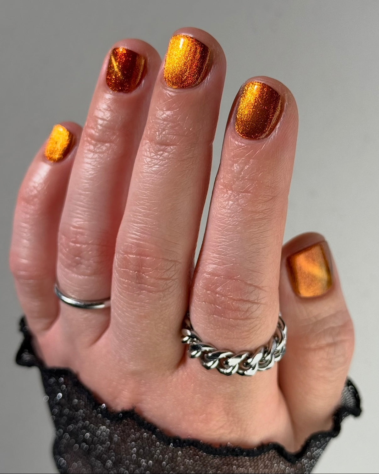 Marigold by Glitch Lacquer, burnt orange jelly, red shimmer, orange-to-gold magnetic, on light skin tone square nails