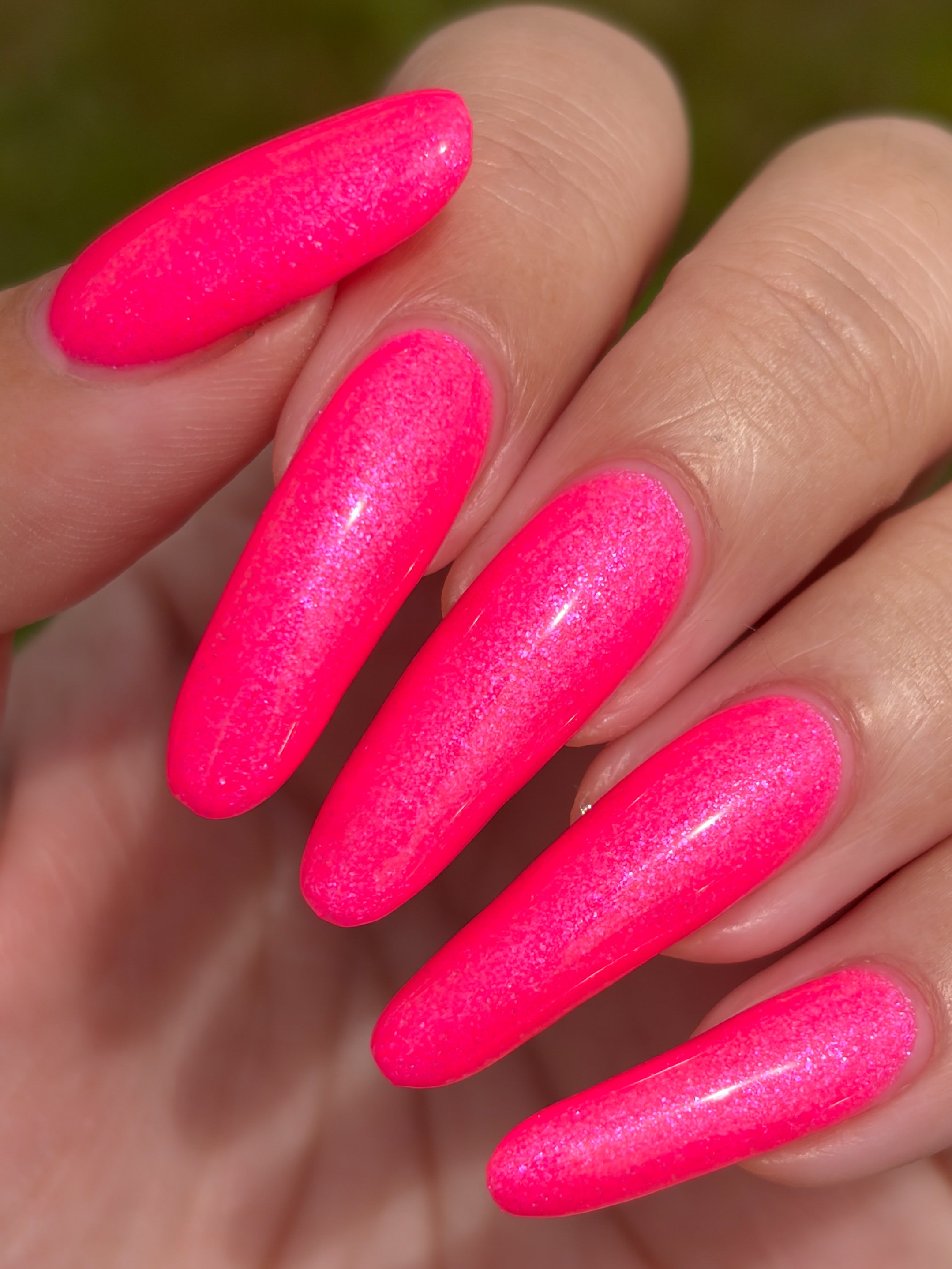 ACT UP by Glitch Lacquer, neon pink crelly with cool-toned pink sparkle, on light-medium skin tone almond nails