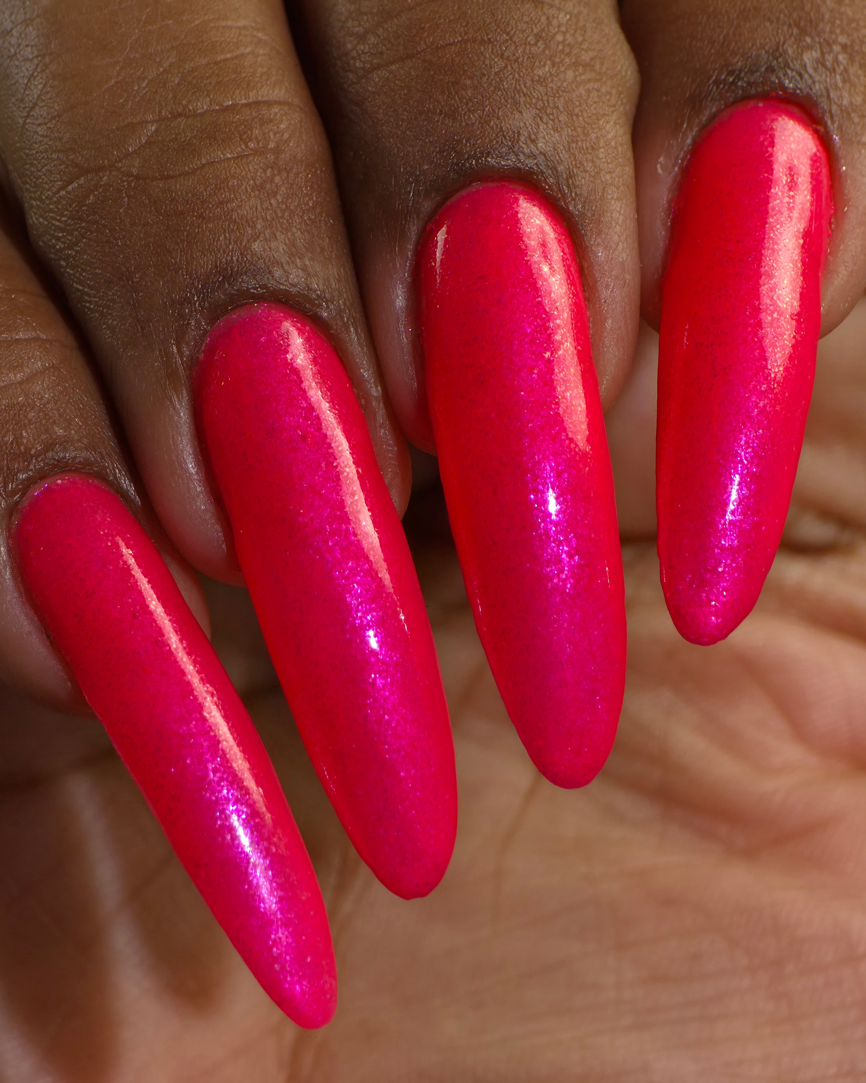 ACT UP by Glitch Lacquer, neon pink crelly with cool-toned pink sparkle, on deep skin tone stiletto nails