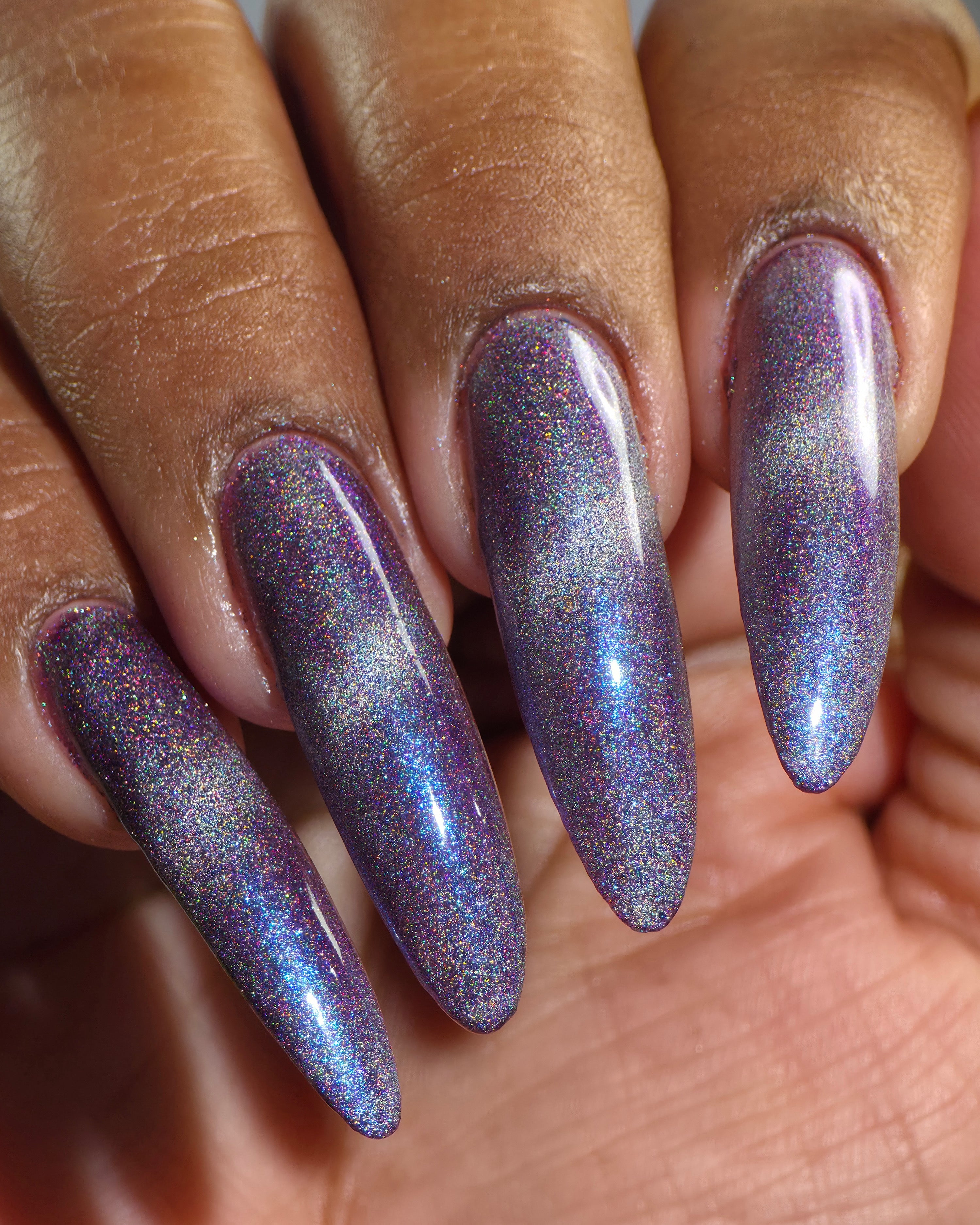 Ally by Glitch Lacquer, silver holographic magnetic topper over mauve-purple, on deep skin tone almond nails