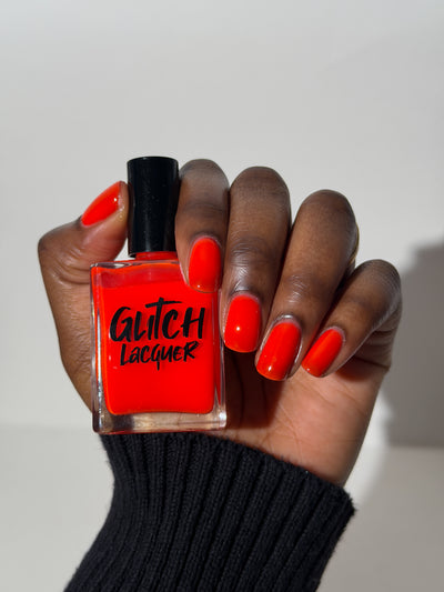 Palestinian Poppy by Glitch Lacquer, warm red crelly shown on a deep skin tone hand