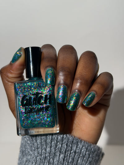 Medo by Glitch Lacquer, teal jelly with iridescent rainbow flakies on a deep skin tone hand