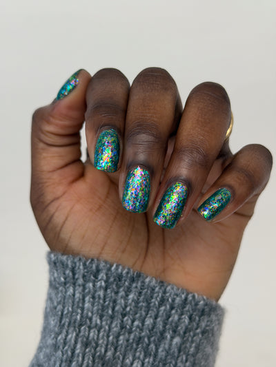 Medo by Glitch Lacquer, teal jelly with iridescent flakies swatch on deep skin, round nails