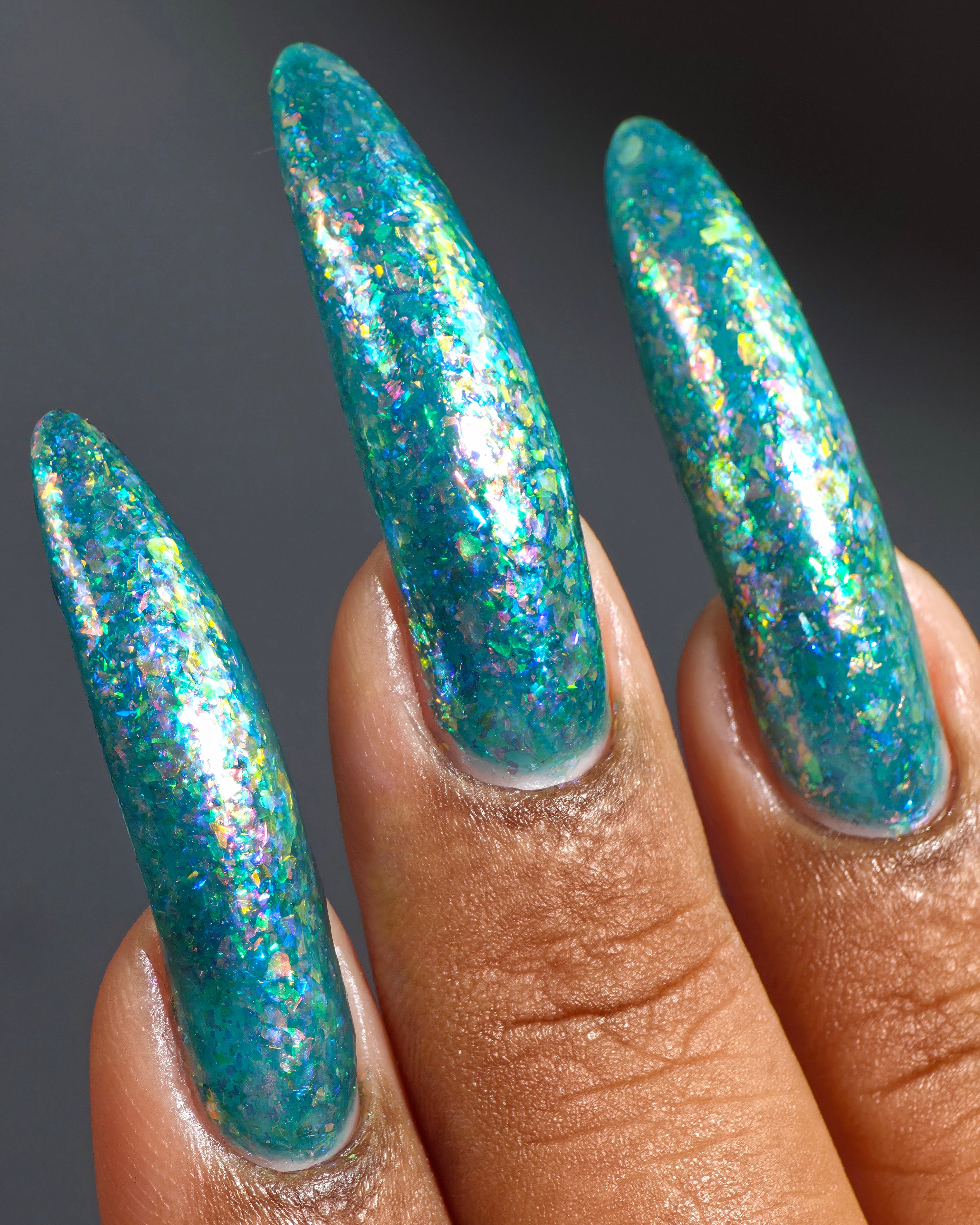 Medo by Glitch Lacquer, teal jelly with iridescent flakies swatch on deep skin, stiletto nails