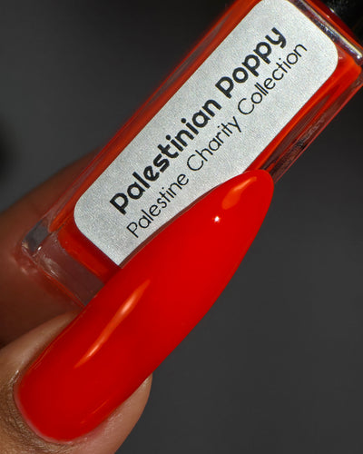 Palestinian Poppy by Glitch Lacquer, warm red crelly bottle held in a deep skin tone hand