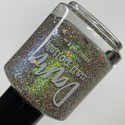 Thyme to Shine by Dam Nail Polish, warm taupe-grey base with green-to-purple multichrome shimmer and scattered silver holographic glitter in studio light, bottle standalone product shot
