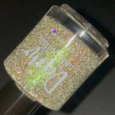 Thyme to Shine by Dam Nail Polish, green-shifting shimmer with dense silver holographic and reflective glitters showing champagne-gold flash, bottle standalone product shot