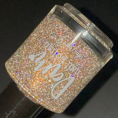 Sunny Side Up by Dam Nail Polish, warm gold shimmer with silver holographic microglitter intensified under direct flash, bottle standalone product shot