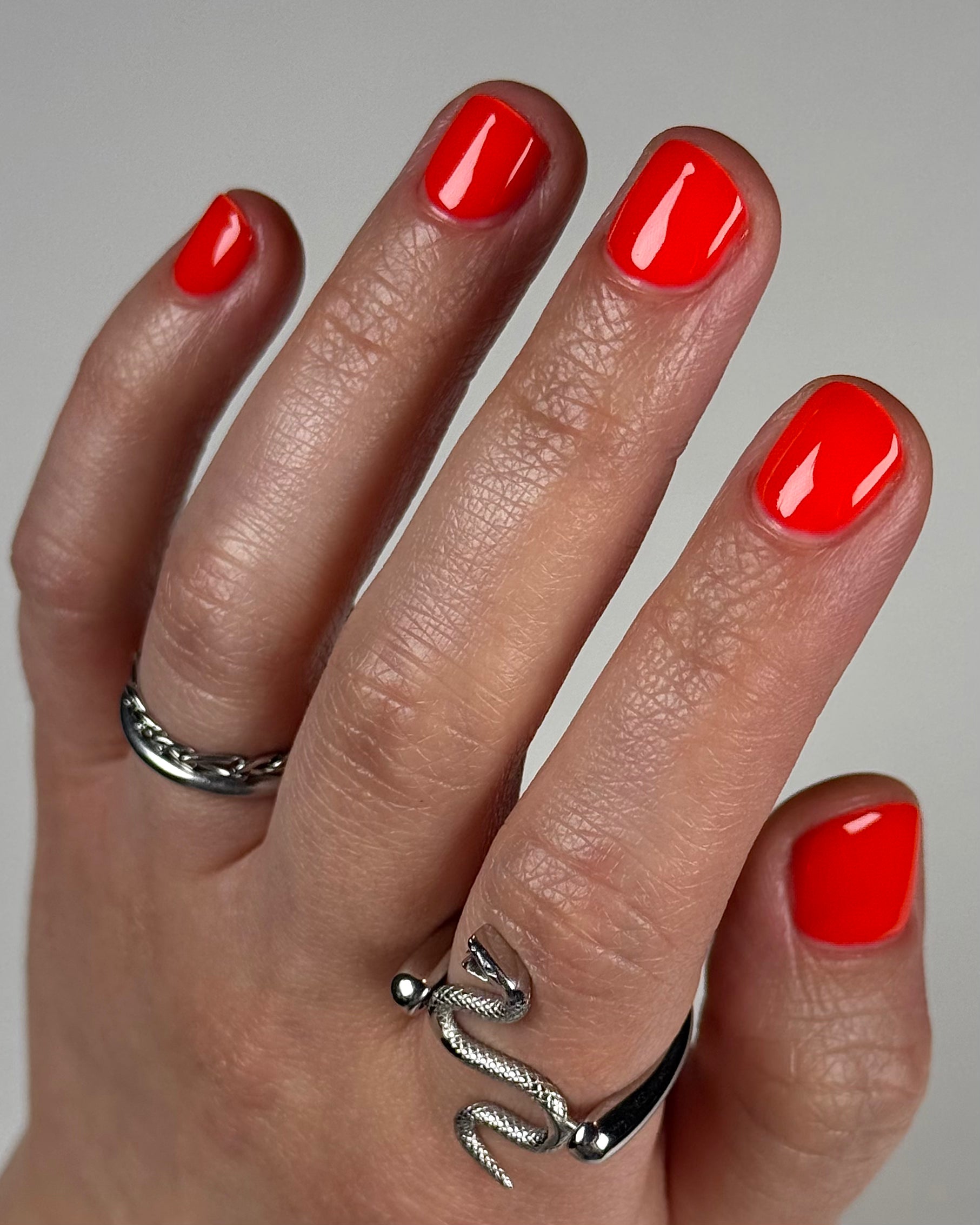 Palestinian Poppy by Glitch Lacquer, warm red crelly swatch on light-medium skin tone, short nails