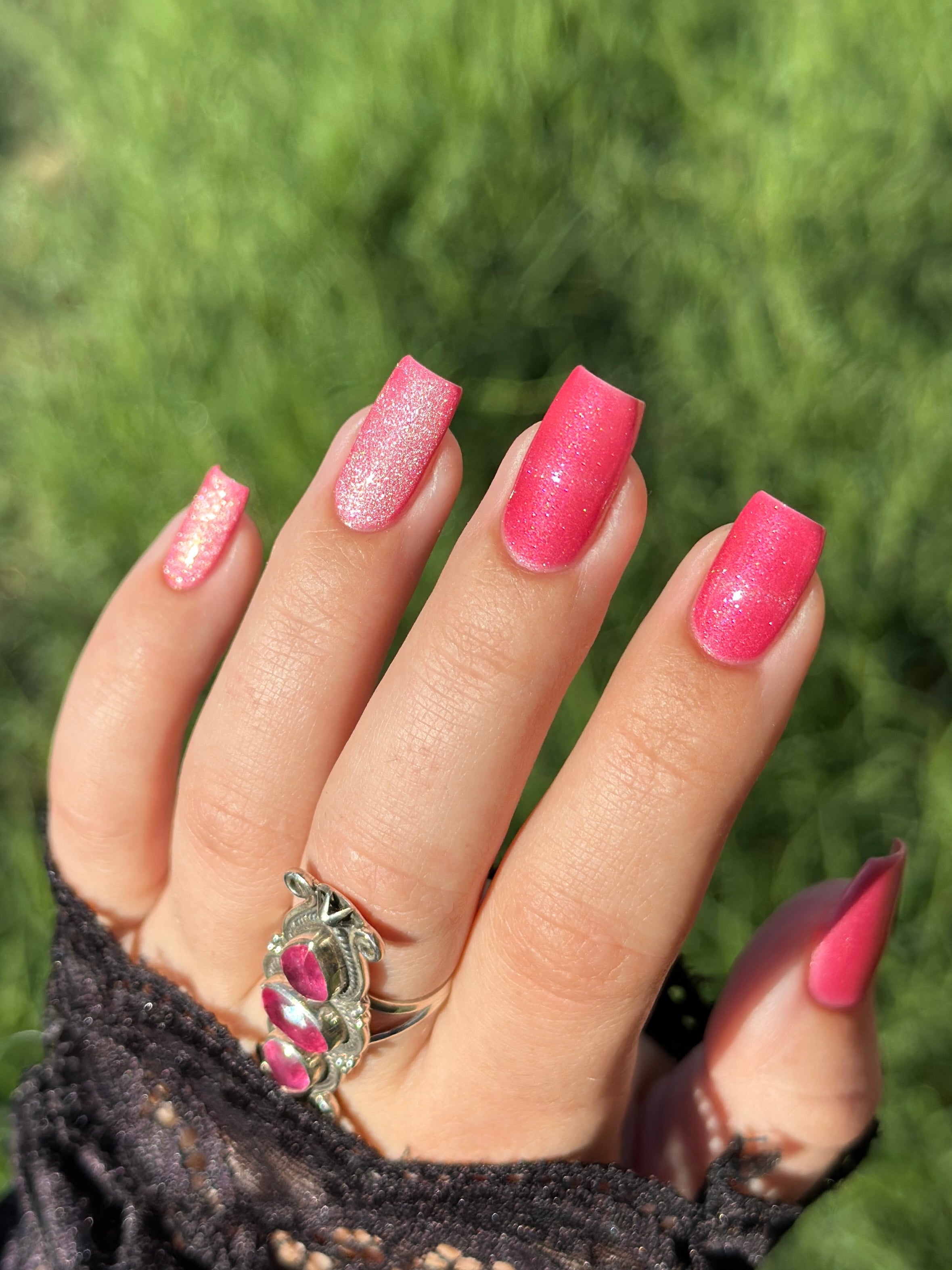 Lovey Dovey by Glitch Lacquer on five squoval nails, warm pink polish with pink-to-gold reflective shimmer and silver magnetic pigment, light-medium skin tone, bright daylight.