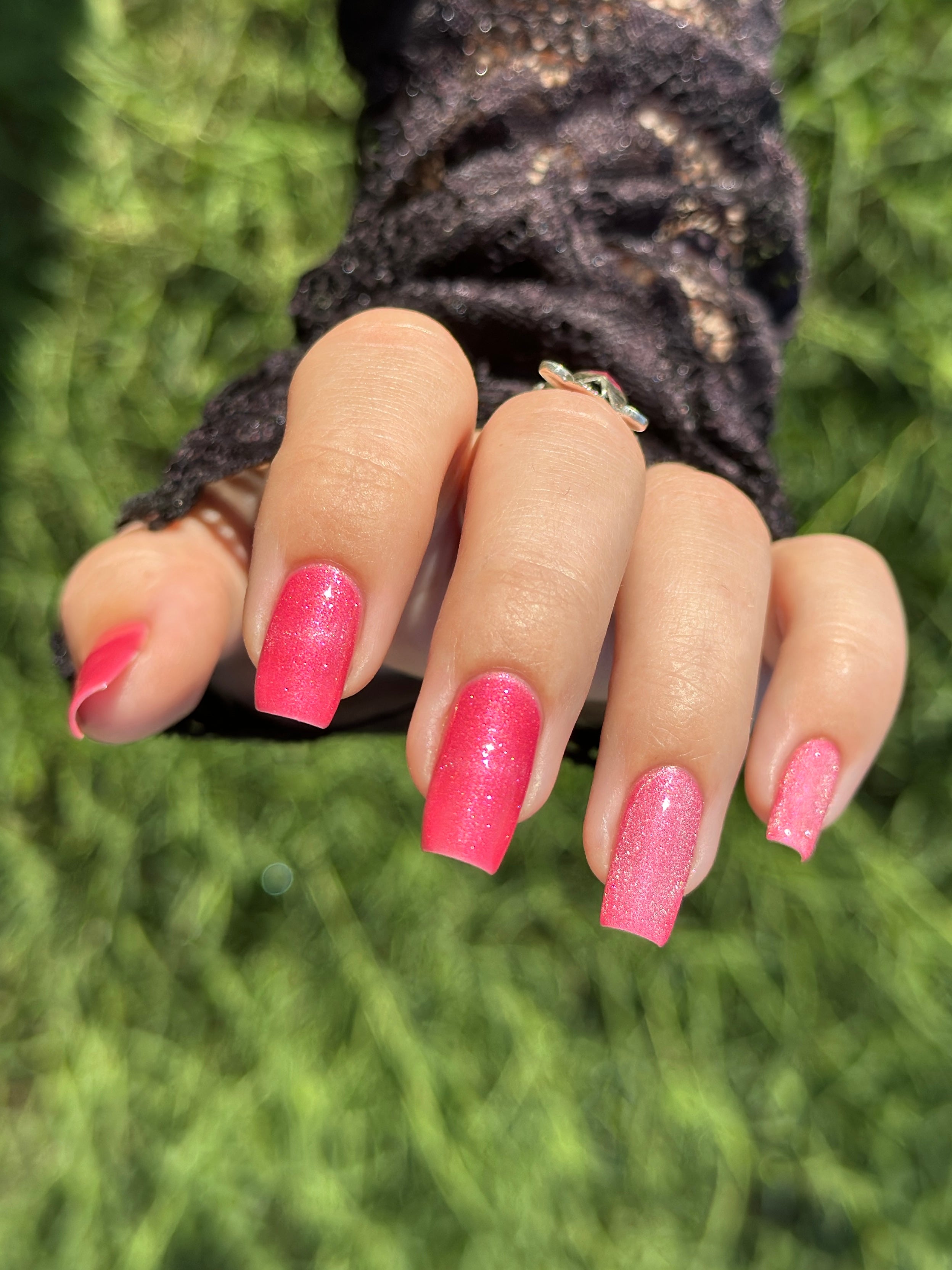 Lovey Dovey by Glitch Lacquer on five square nails, warm pink polish with pink-to-gold reflective shimmer, light-medium skin tone, bright daylight.