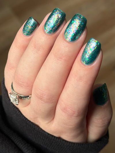 Medo by Glitch Lacquer, teal jelly with iridescent flakies on light skin, round nails