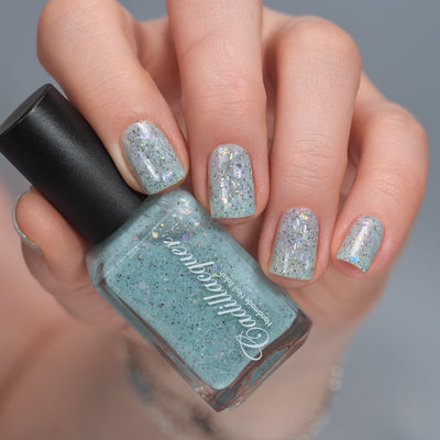 Cadillacquer Fresh Sheets pastel mint iridescent crelly nail polish, bottle held with four-nail swatch, light skin, studio lighting