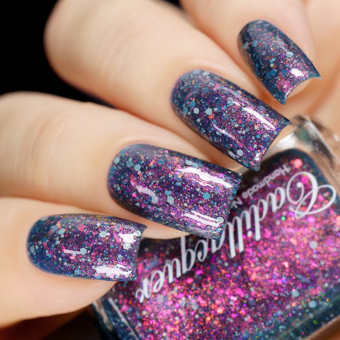 Jelly shimmer flakie Cadillacquer nail polish in I Don't Belong To You, a dark blue jelly with pink to orange to yellow shimmer, flakies and matte grey glitter, swatched on nails