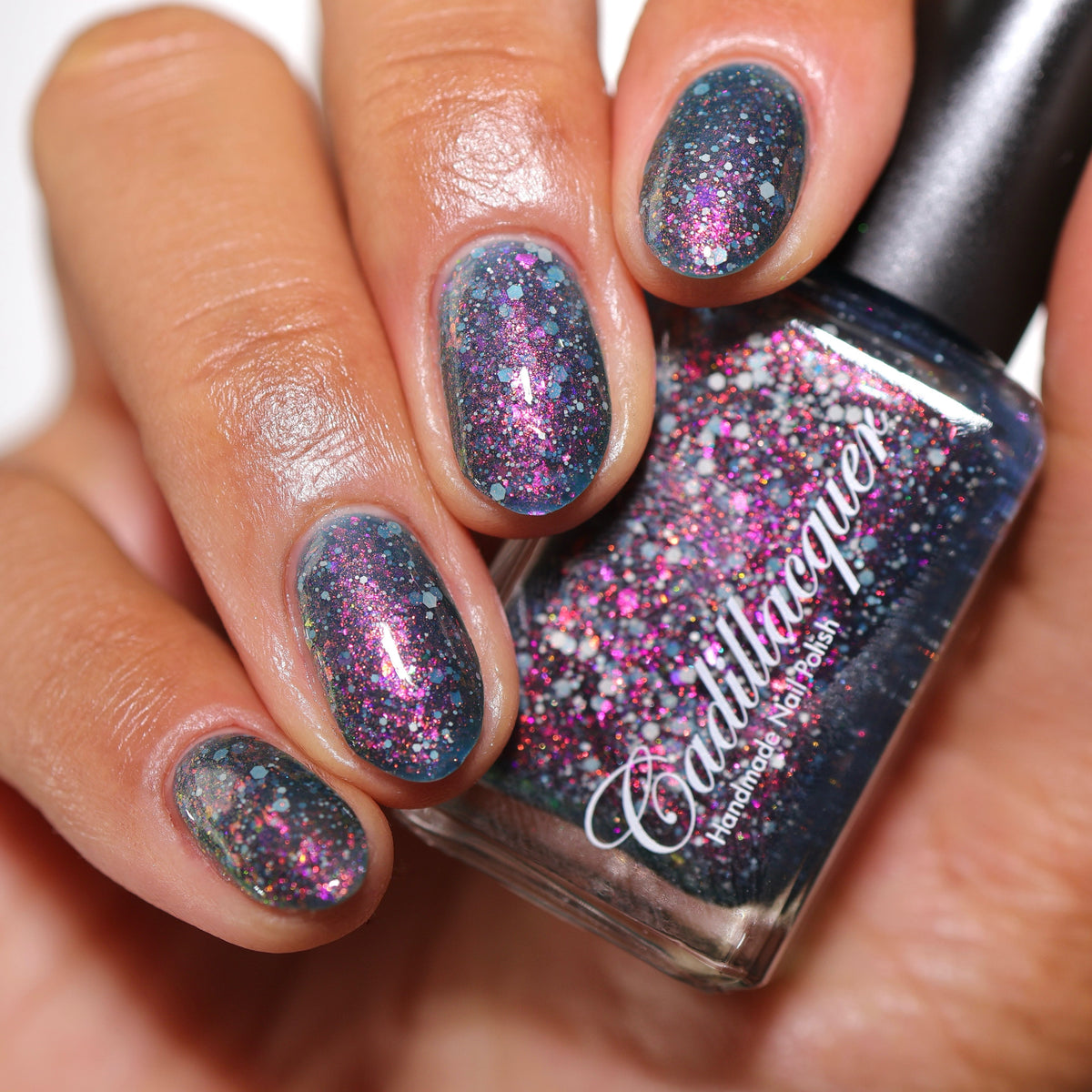 Close-up of Cadillacquer I Don't Belong To You showing pink to yellow shimmer and grey glitter in blue jelly