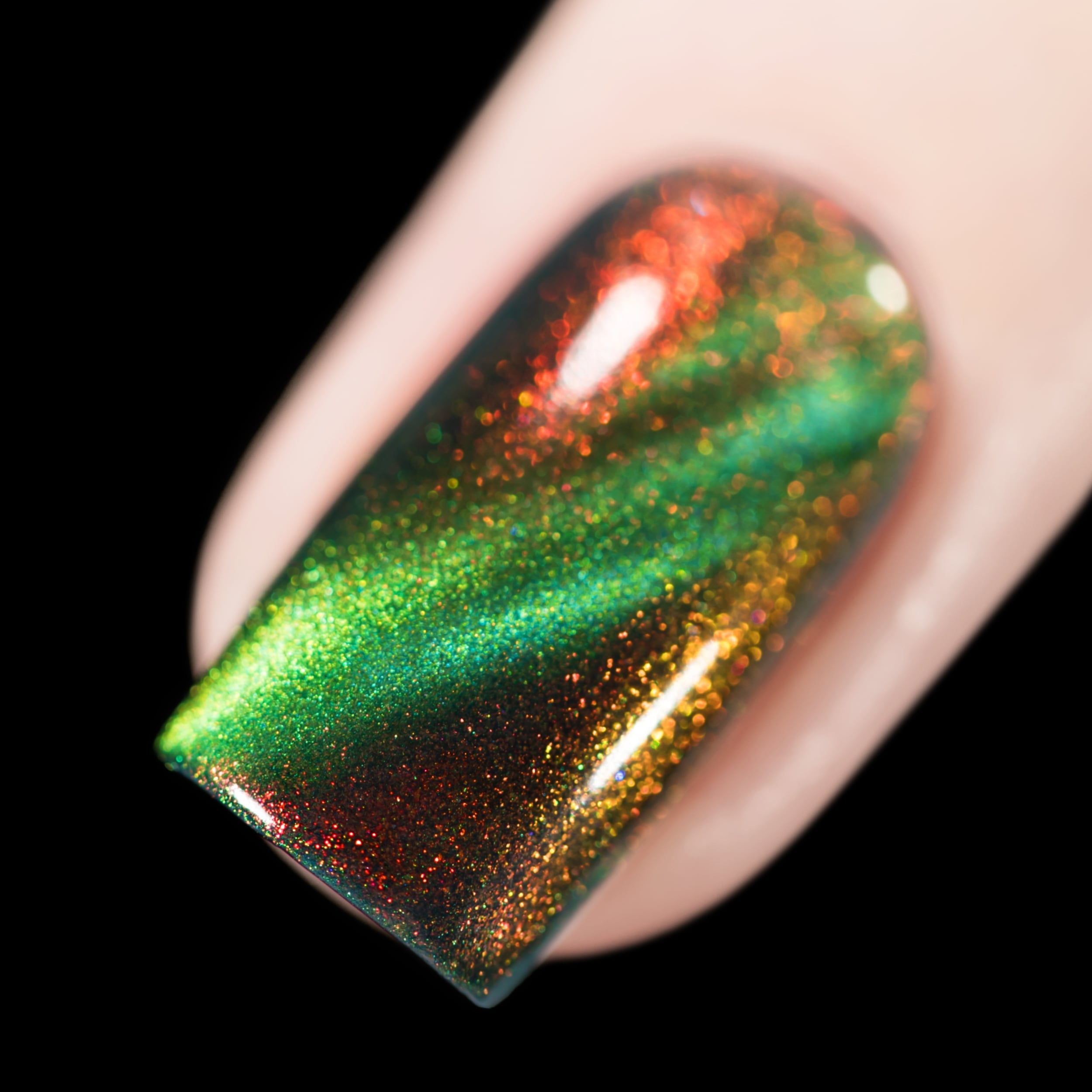 Holographic multichrome magnetic Cadillacquer nail polish in I Found A Place, shown as a macro swatch on a single square nail, shifting from deep teal-green in the field through amber-gold to vivid red-orange aurora flash at the tip, with a bright lime-green magnetic band arc, light skin tone, direct flash lighting, swatched by @rafinails