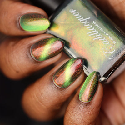 Magnetic multichrome shimmer Cadillacquer nail polish in I Found A Place, swatched on five almond-shaped nails showing a deep olive-green field with a vivid lime-green magnetic band and sweeping red-to-orange aurora shimmer, on rich skin tone, studio lighting, swatched by @doseoflolade