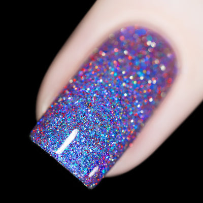 Holographic glitter and shimmer Cadillacquer nail polish in I'll Be Right Back, shown as a macro swatch on a single square nail packed with blue micro flakes, vivid red and charcoal reflective glitter, and icy blue shimmer against a clear base, light skin tone, shot under direct flash on a black background, swatched by @rafinails