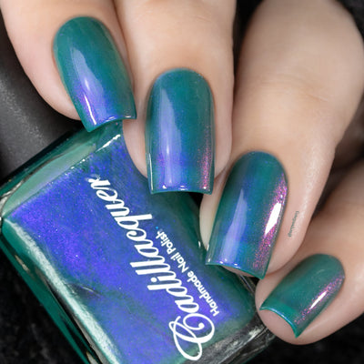 Multichrome shimmer Cadillacquer nail polish in It's All For You, swatched on four square nails showing a teal green base with vivid violet-indigo to magenta-pink shimmer shift, on light skin tone, studio lighting, with bottle visible showing matching teal edge and blue-violet shimmer face, swatched by @serpentine13