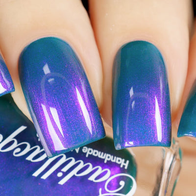 Multichrome shimmer Cadillacquer nail polish in It's All For You, shown as swatch on four squoval nails shifting from teal green at face-on angles to vivid violet-purple shimmer under direct light, with bottle partially visible in lower frame, light skin tone, studio lighting, swatched by @yyulia_m