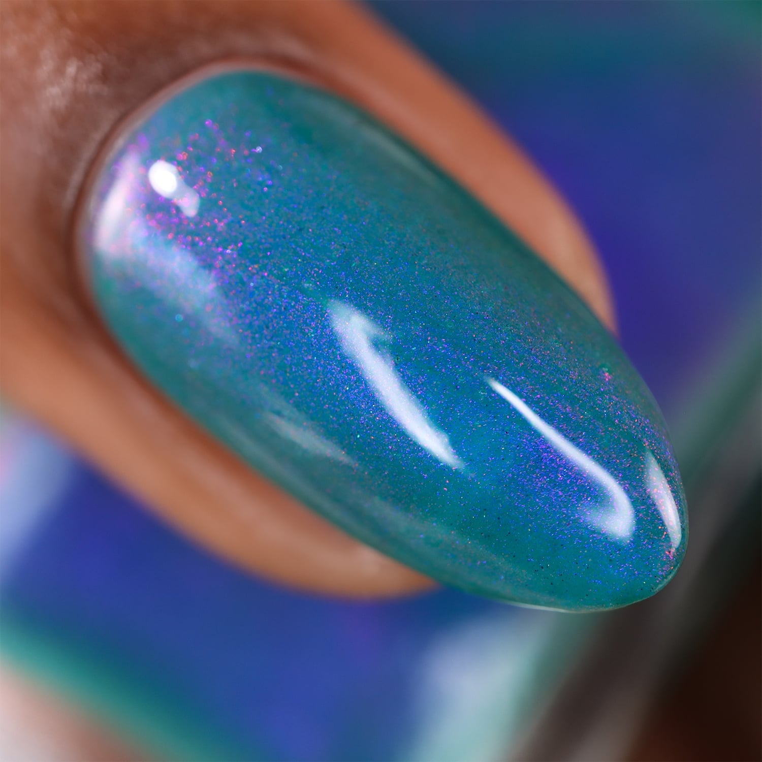 Multichrome shimmer Cadillacquer nail polish in It's All For You, macro swatch on a single almond-shaped nail showing teal green crelly base packed with violet-purple and magenta shimmer that shifts to blue at angular light, on medium-deep skin tone, studio lighting, swatched by @doseoflolade