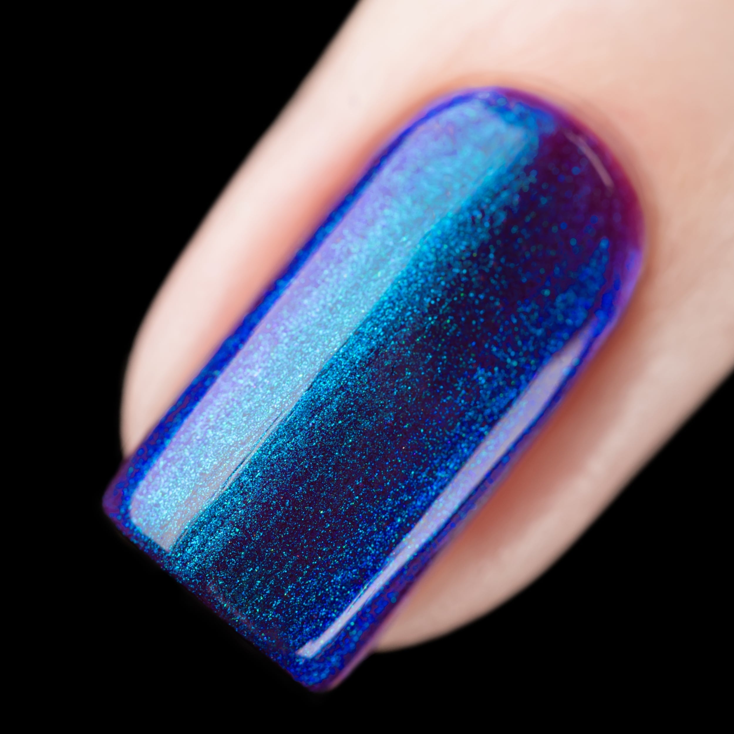 Holographic multichrome shimmer Cadillacquer nail polish in Keep Doubting, macro swatch on a single square nail showing deep indigo-mulberry base shifting through cobalt blue and cyan-teal shimmer with violet at the edges, light skin tone, studio lighting on black background, swatched by @rafinails