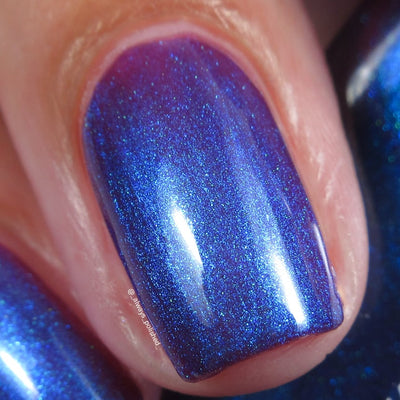 Shimmer multichrome Cadillacquer nail polish in Keep Doubting, macro swatch on two short natural nails showing a deep violet-mulberry base densely packed with electric blue shimmer that shifts to teal-green at oblique angles, on light skin tone, studio lighting, swatched by @_always_polished_
