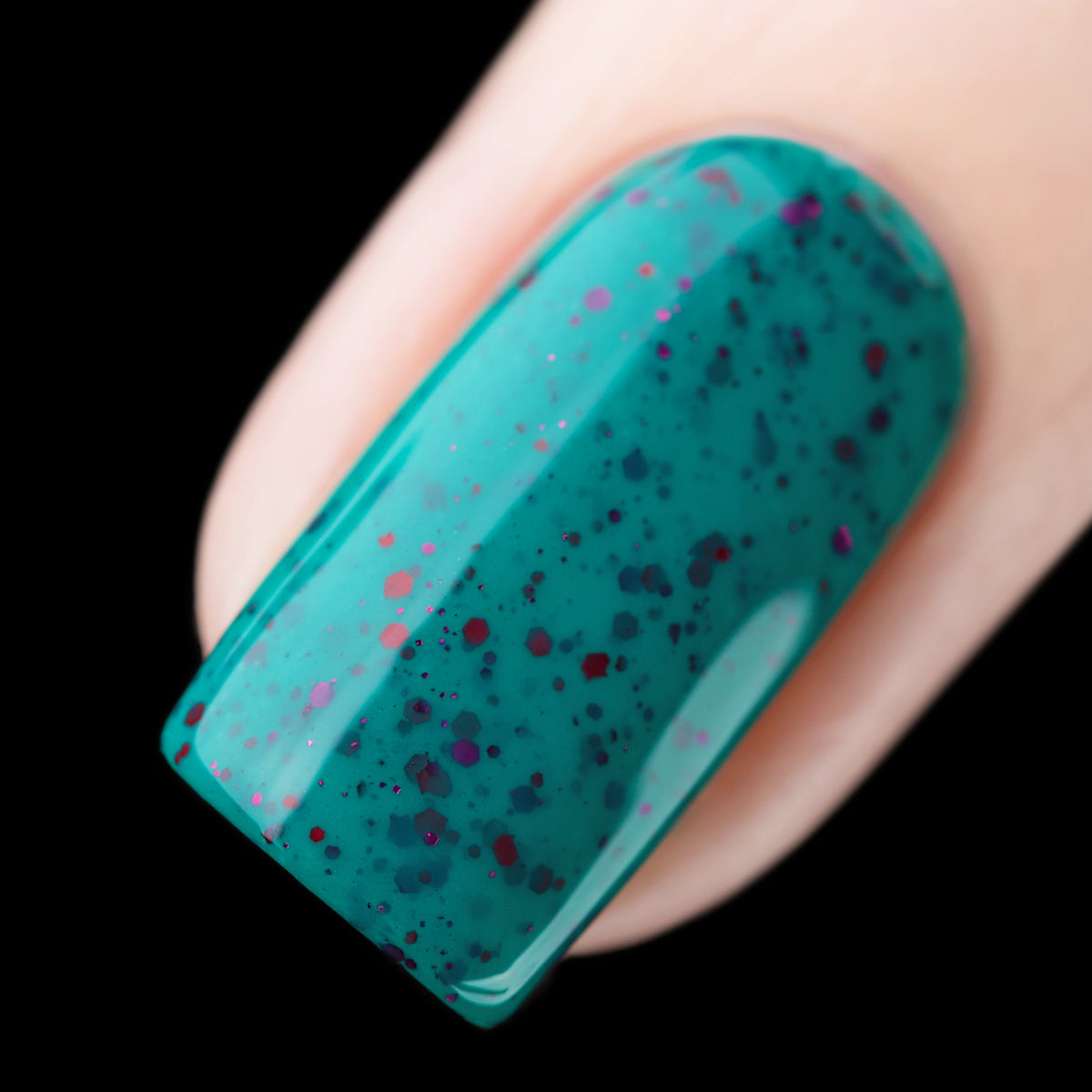 Close-up of Cadillacquer Siren nail polish showing red glitter suspended in teal crelly, swatched by @rafinails