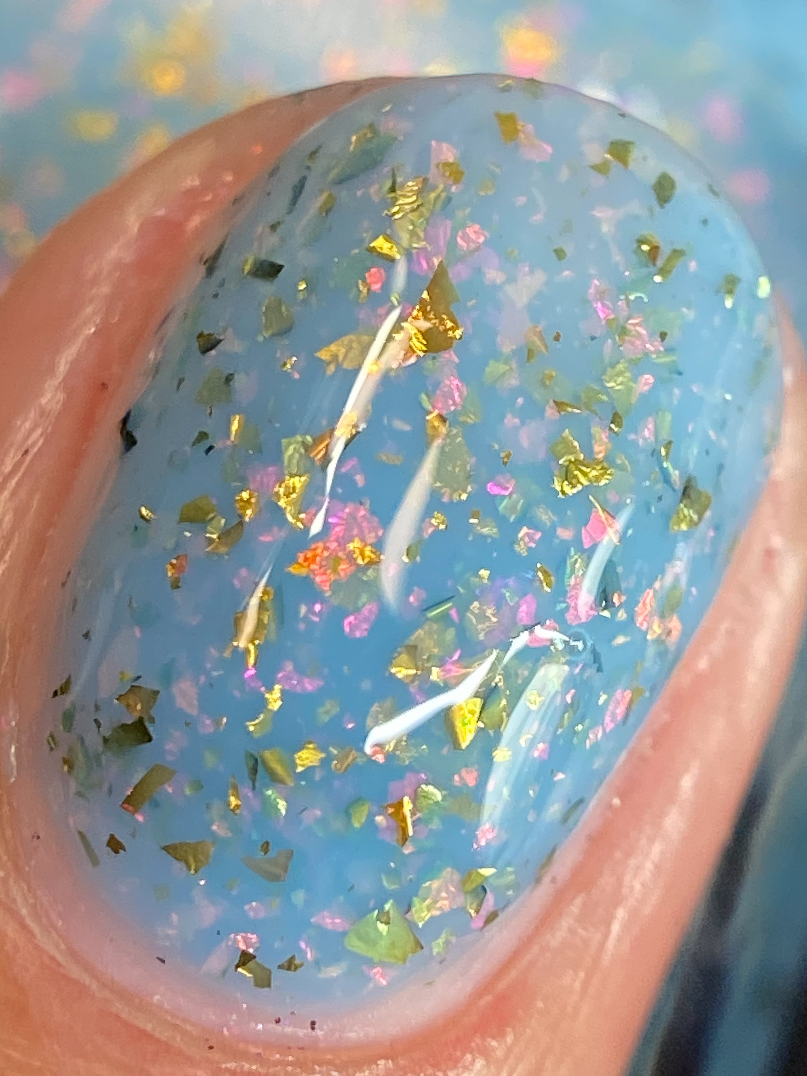 Cadillacquer Slow Mornings light blue gold chameleon iridescent crelly nail polish, macro single-nail swatch, light skin, bright daylight lighting