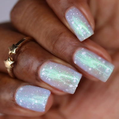 Jelly shimmer Cadillacquer nail polish in Spotted Glass Frog, a light pastel blue jelly with green to blue shimmer and matte white glitter, swatched on nails