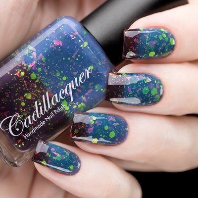 Thermal glitter and iridescent flake Cadillacquer nail polish in Strange Happenings, shown in bottle held alongside five swatched nails transitioning from blackened eggplant cold state to dusty teal-blue warm state, loaded with matte neon green hex and dot glitter and pink-to-orange iridescent flakes, light skin tone, studio lighting, swatched by @rafinails