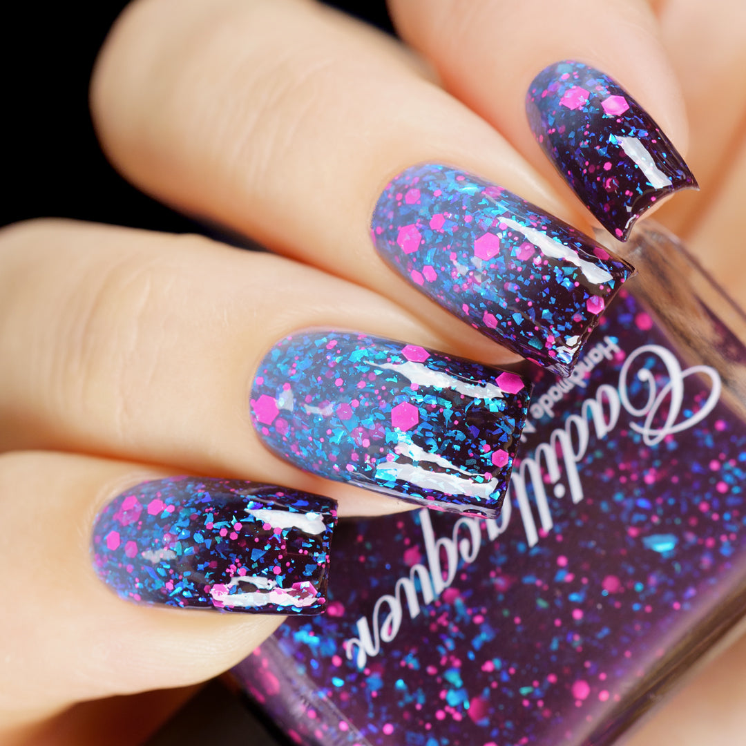 Thermal glitter-and-flake Cadillacquer nail polish in What Lurks Within, shown on five squoval nails transitioning from deep blackened eggplant (cold) to blue-grey (warm), loaded with matte neon pink hex glitter and cyan iridescent flakes, alongside a matching bottle, on light skin tone under studio lighting, swatched by @yyulia_m