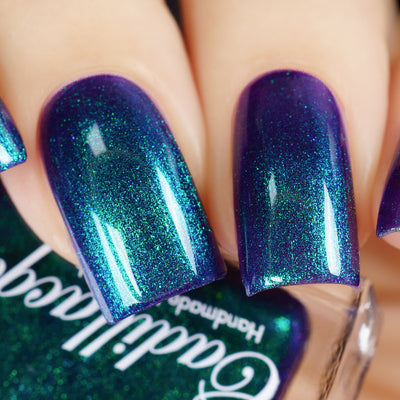 Multichrome shimmer Cadillacquer nail polish in What Could Possibly Go Wrong?, swatched on four square nails showing a deep violet-indigo base packed with intense green-to-blue shifting fine shimmer, light skin tone, studio lighting, swatched by @yyulia_m