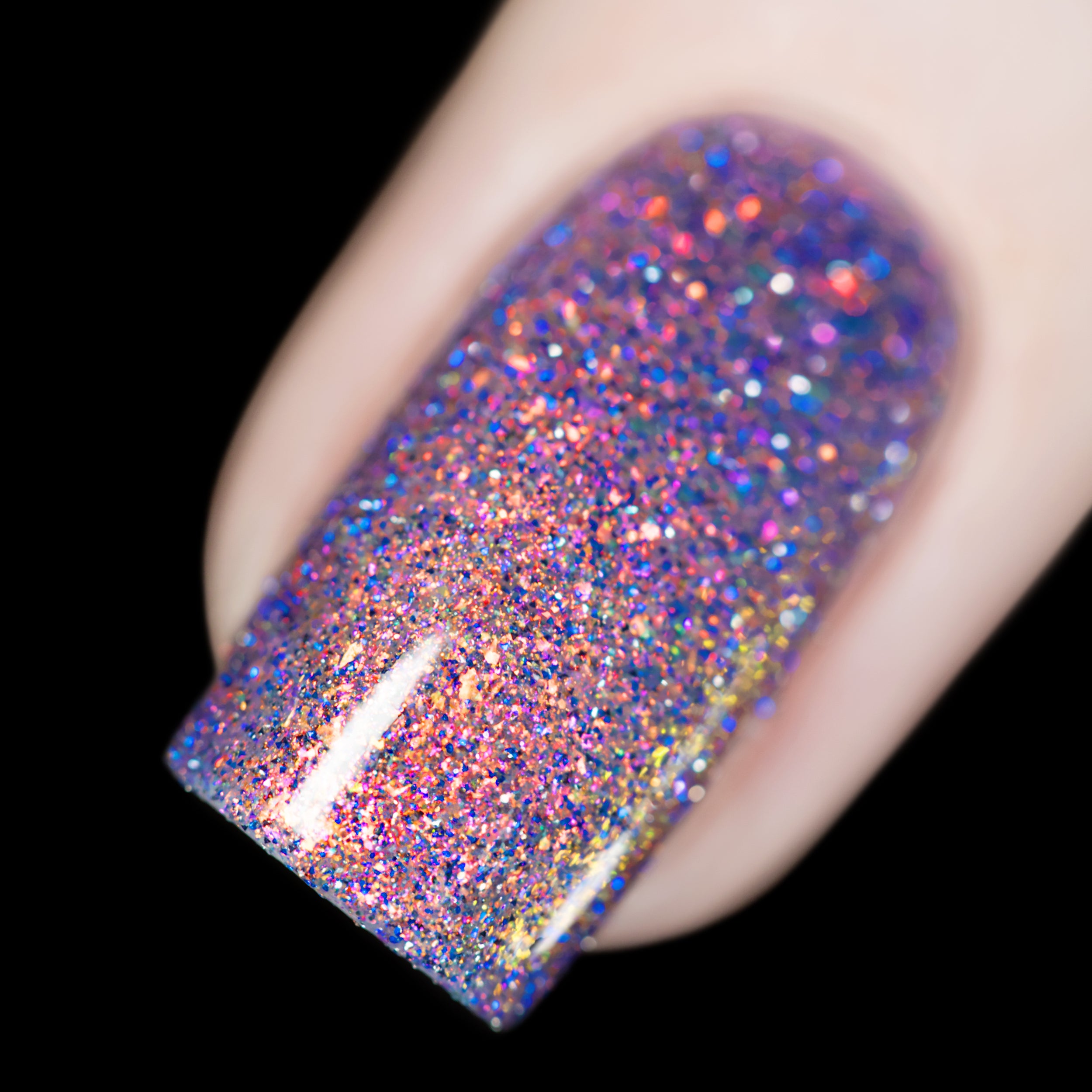 Holographic multichrome glitter and micro-flake Cadillacquer nail polish in You Wished For This, shown as a macro swatch on a single square nail, densely packed iridescent micro flakes shifting from red-orange through gold and pink to violet with scattered blue and silver holographic glitter, on light skin tone, studio lighting, swatched by @rafinails