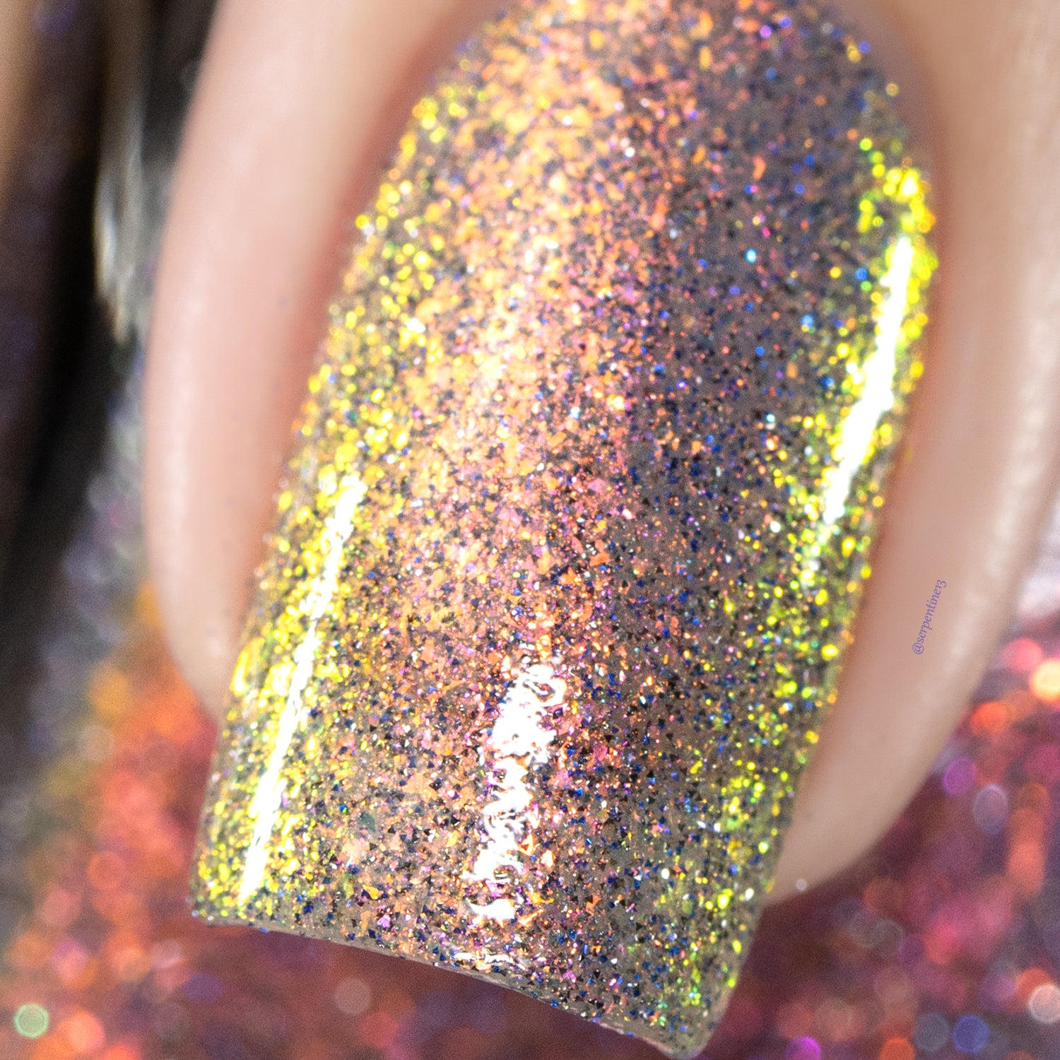Iridescent multichrome flake and reflective glitter Cadillacquer nail polish in You Wished For This, extreme macro closeup of a single square nail showing densely packed micro flakes shifting from yellow-green through copper-orange to pink-mauve, scattered with charcoal and blue holographic micro glitter, on a light skin tone, studio lighting, swatched by @serpentine13