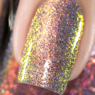 Iridescent multichrome flake and reflective glitter Cadillacquer nail polish in You Wished For This, extreme macro closeup of a single square nail showing densely packed micro flakes shifting from yellow-green through copper-orange to pink-mauve, scattered with charcoal and blue holographic micro glitter, on a light skin tone, studio lighting, swatched by @serpentine13